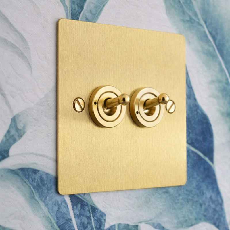 Elite flat plate range brass colour double light switch on a hotel guest room wall by Hotel Lock and Safe