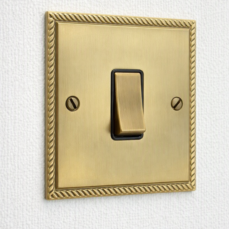 Georgian elite range gold colour single light switch with bezzled edge screwed to a hotel room wall by Hotel Lock and Safe