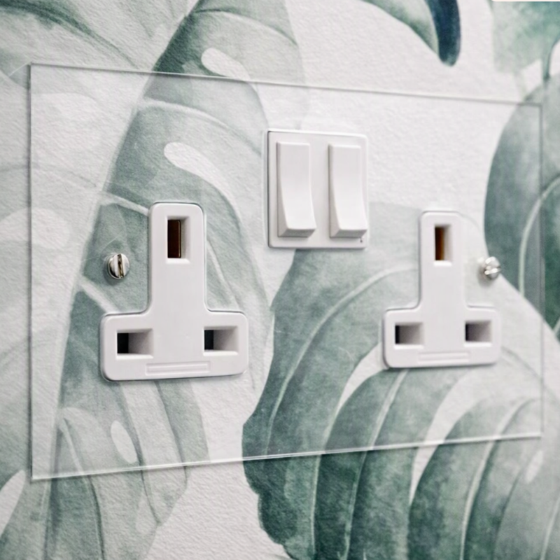 clear perspex double wall socket fixed on a wall in a hotel guest room by Hotel Lock and Safe