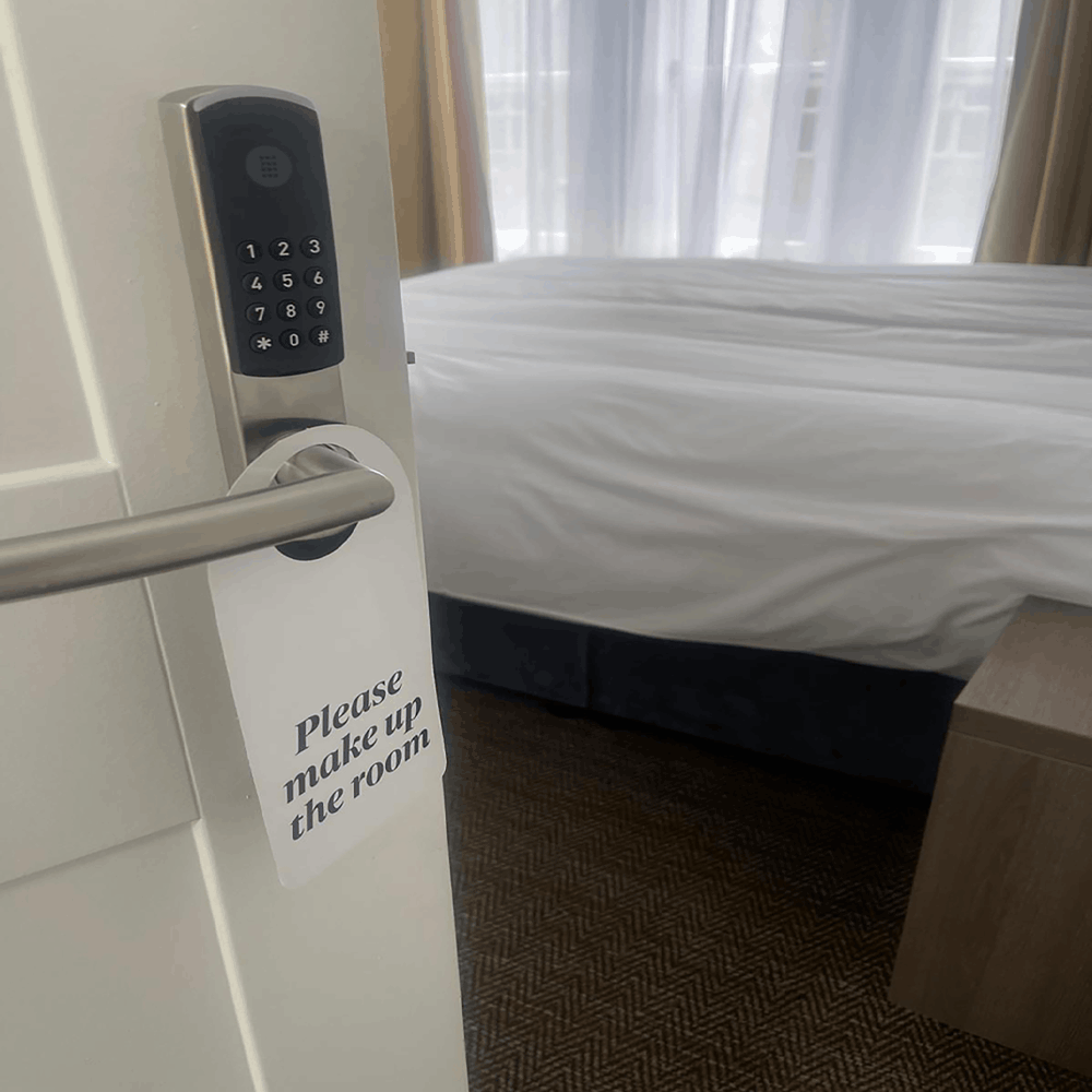 Omnitec os slim code hotel door lock in silver on a hotel door with a sign placed on the handle by hotel lock and safe