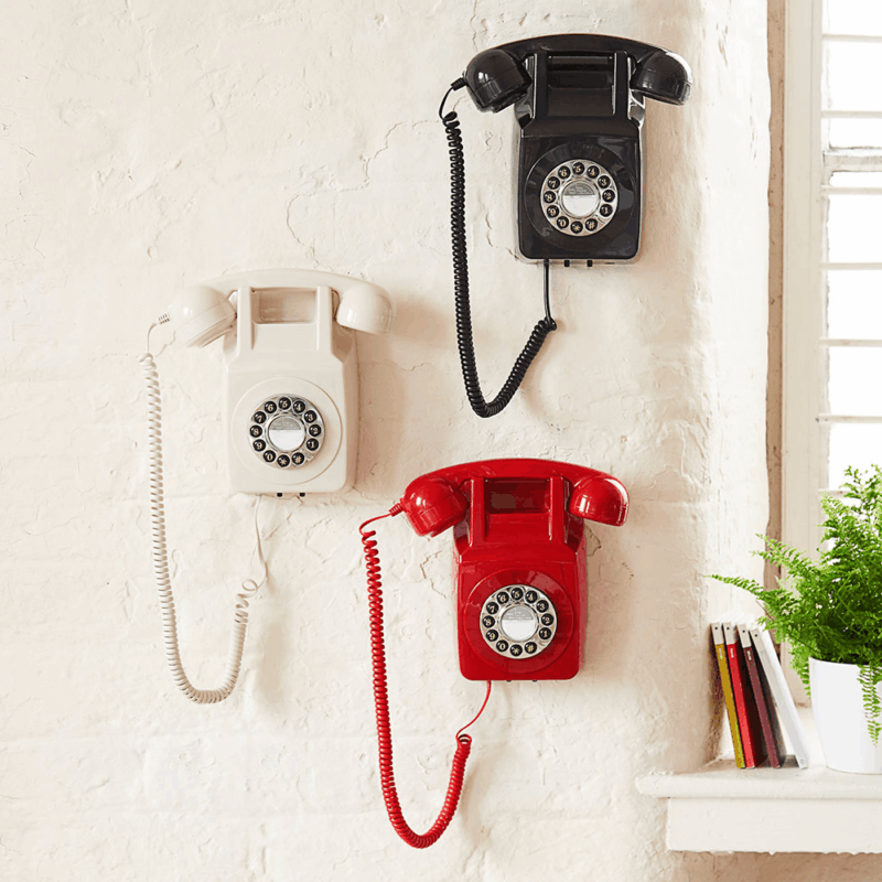 three hotel wall mounted SIP phone sin black white and red fixed to a wall in a hotel