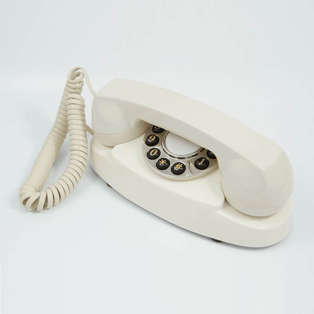 GPO Audrey Hotel guest room push button dialling phone in cream / ivory with curly cloth cord by hotel lock and safe