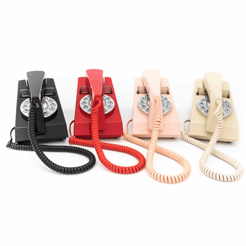GPO Trim hotel guest phone in red black pink and cream with push button dial lined up next to each other by hotel lock and safe