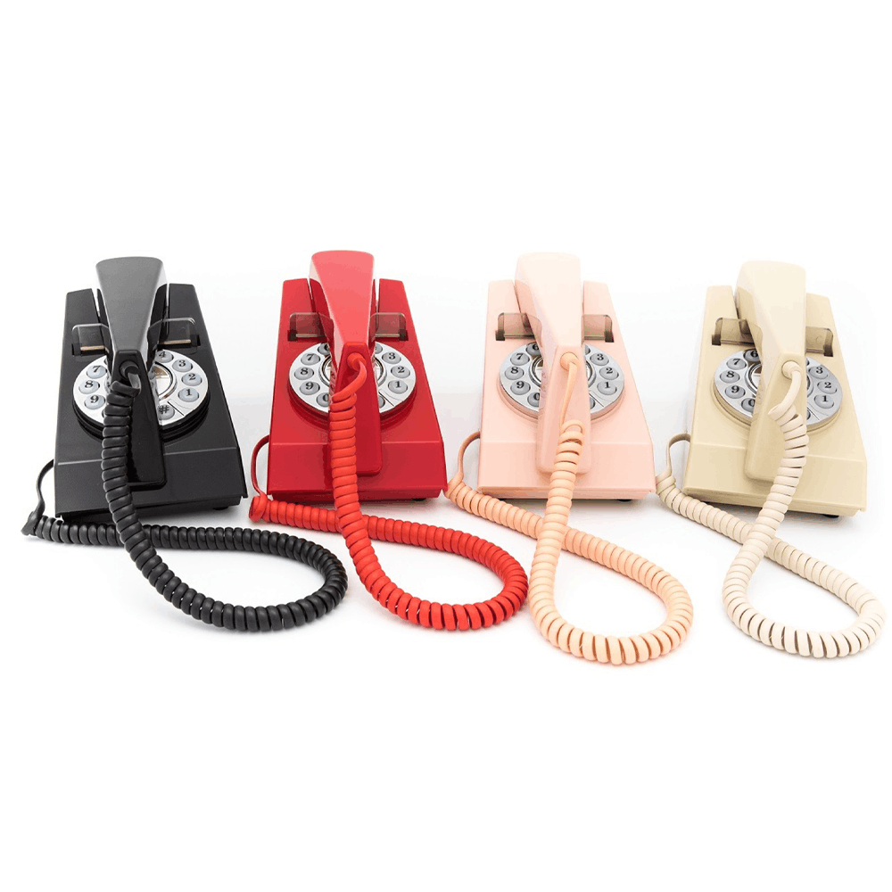 GPO Trim hotel guest phone in red black pink and cream with push button dial lined up next to each other by hotel lock and safe