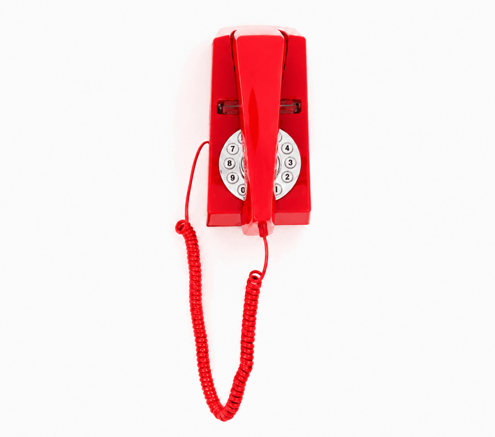 Hotel guest room GPO Trim push button phone in Red wall mounted on a white background by hotel lock and safe