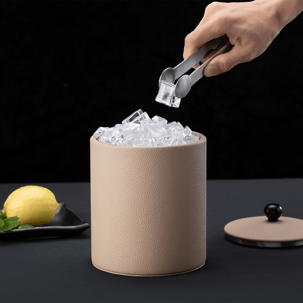 Hand using tongs to lift ice from the Warm Beige SLUSH leatherette ice bucket